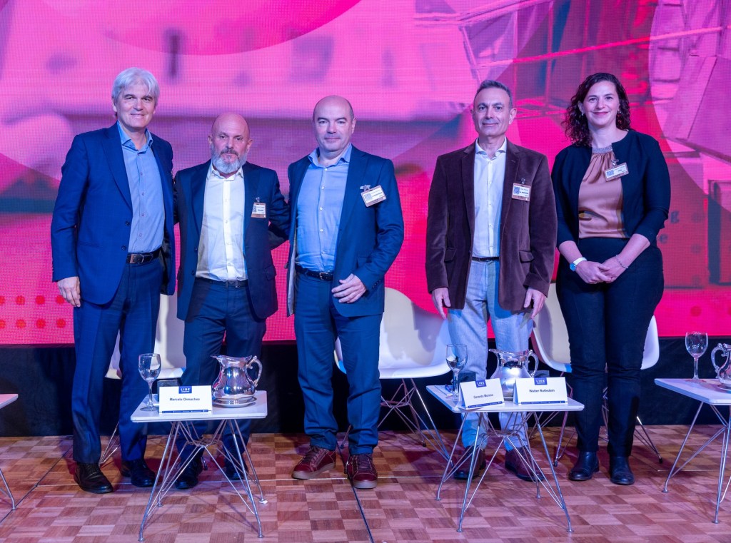 Panel de expertos en el IV Fórum Nacional de Mercado, Consumo & Logística en el Alvear Palace Hotel de Buenos Aires, Argentina. Cinque personas posan frente a un fondo colorido.