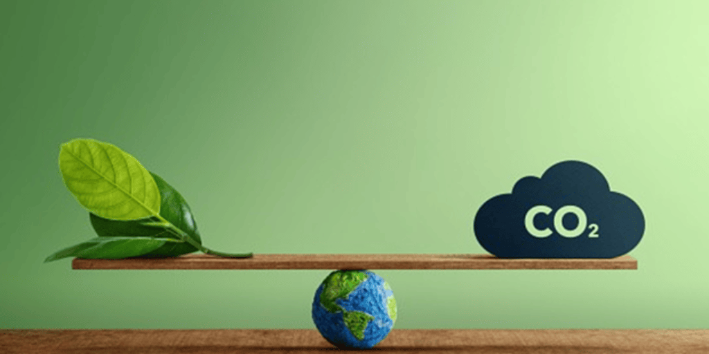 A wooden balance beam featuring a globe on one side and a leaf and a CO2 cloud symbol on the other, representing environmental balance.