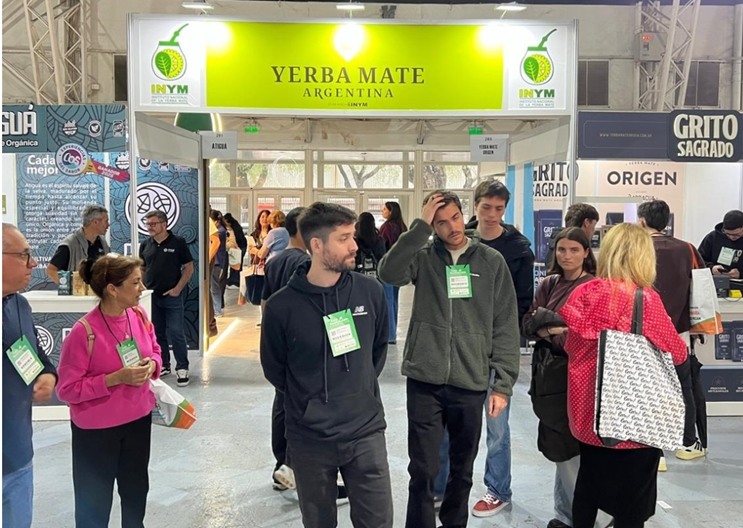 Visita a la Feria DieteticActiva Expo Retail Saludable en Buenos Aires, con un stand destacado de Yerba Mate Argentina, donde se observan asistentes interactuando y explorando productos relacionados con la alimentación saludable.